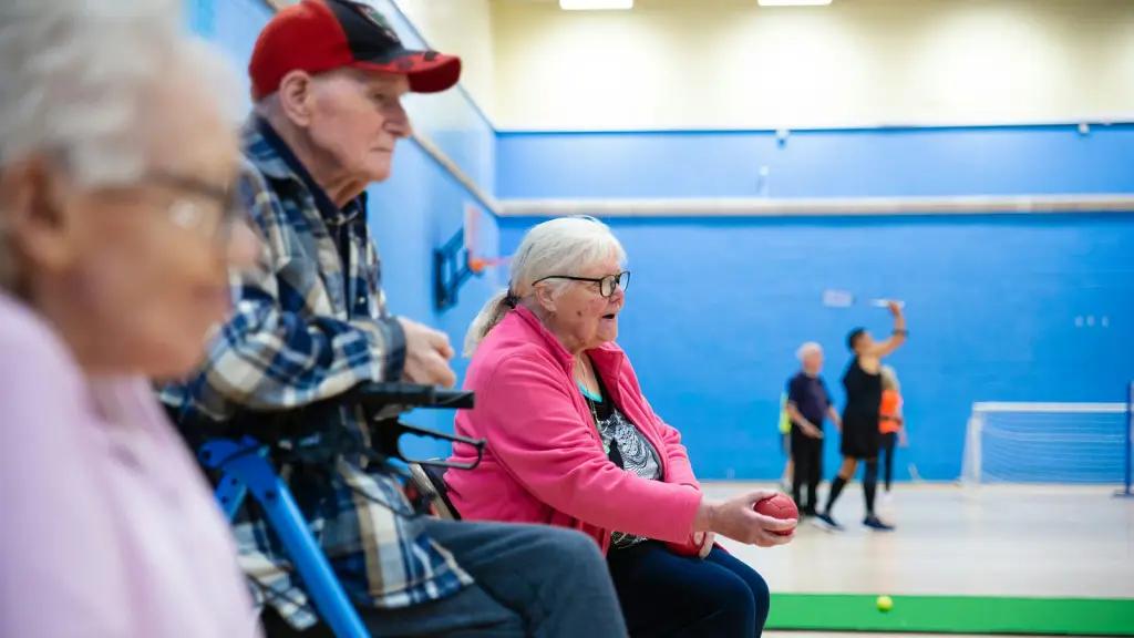 Older people watching a game in a community centre sports hall
