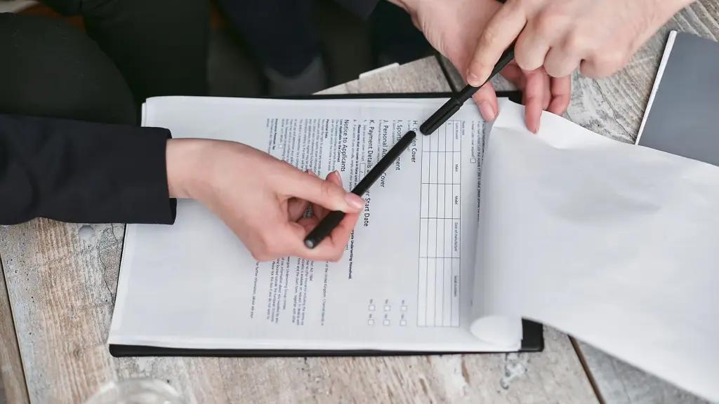 Two people working through a printed checklist with a pen