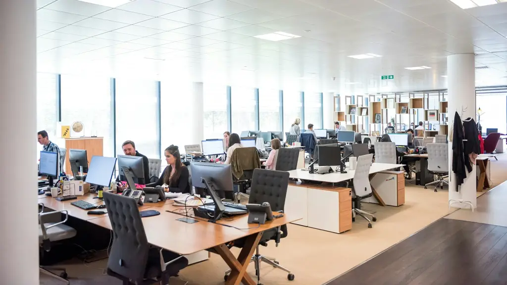 An open-plan office with rows of desks and office chairs