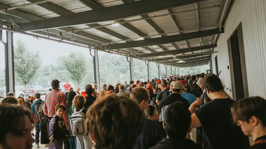A long queue of people waiting to get into a venue under a covered walkway